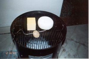 Sharp cheddar and gouda cheeses cold smoking in the WSM