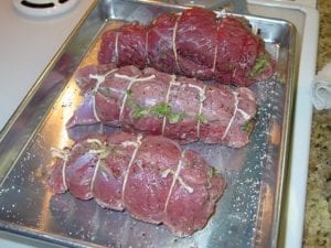 Three tied lamb roasts seasoned with salt & pepper