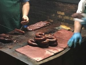 Sausage rings and ribs laid out on butcher block